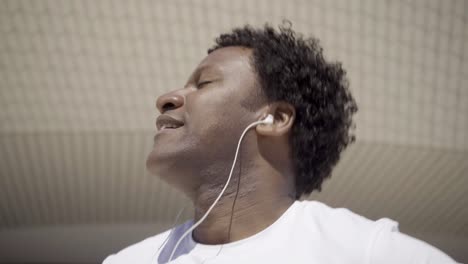 Tired-sportsman-listening-music-while-resting-during-training.